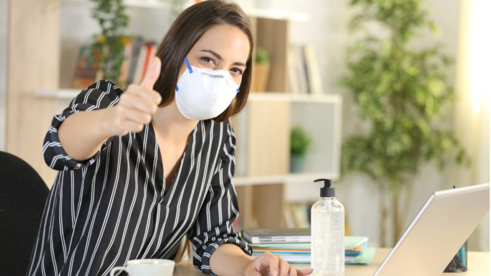 Woman with thumbs up teleworking in coronavirus quarantine